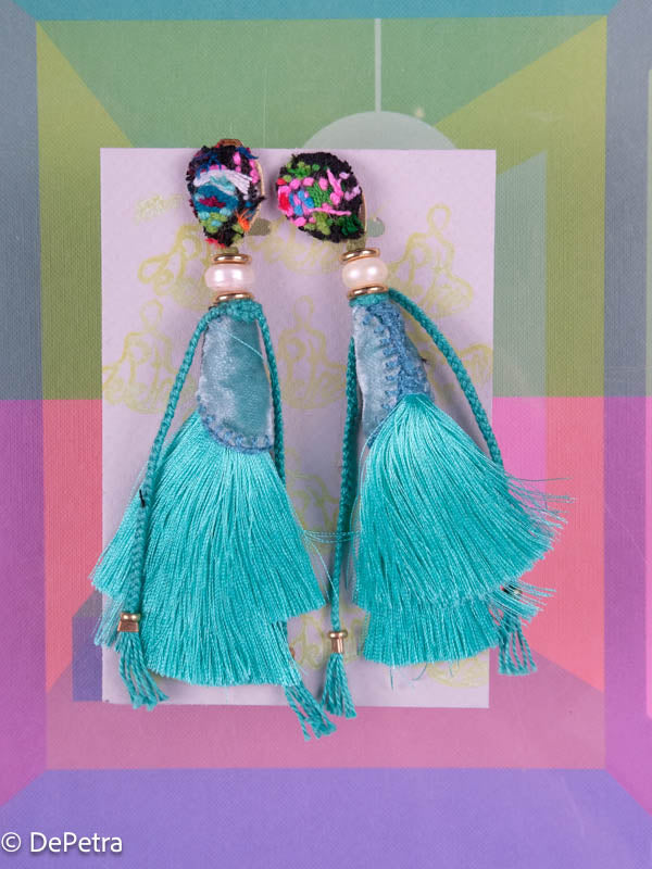 A whimsical and playful pair of earrings feature a long silk tassel. They  are made of high-quality materials and are sure to turn heads wherever you 