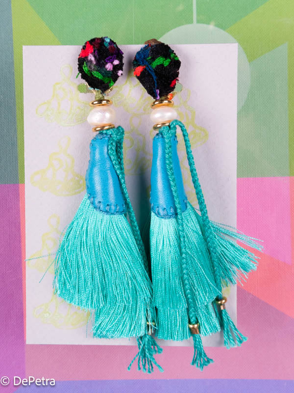 A whimsical and playful pair of earrings feature a long silk tassel. They  are made of high-quality materials and are sure to turn heads wherever you 